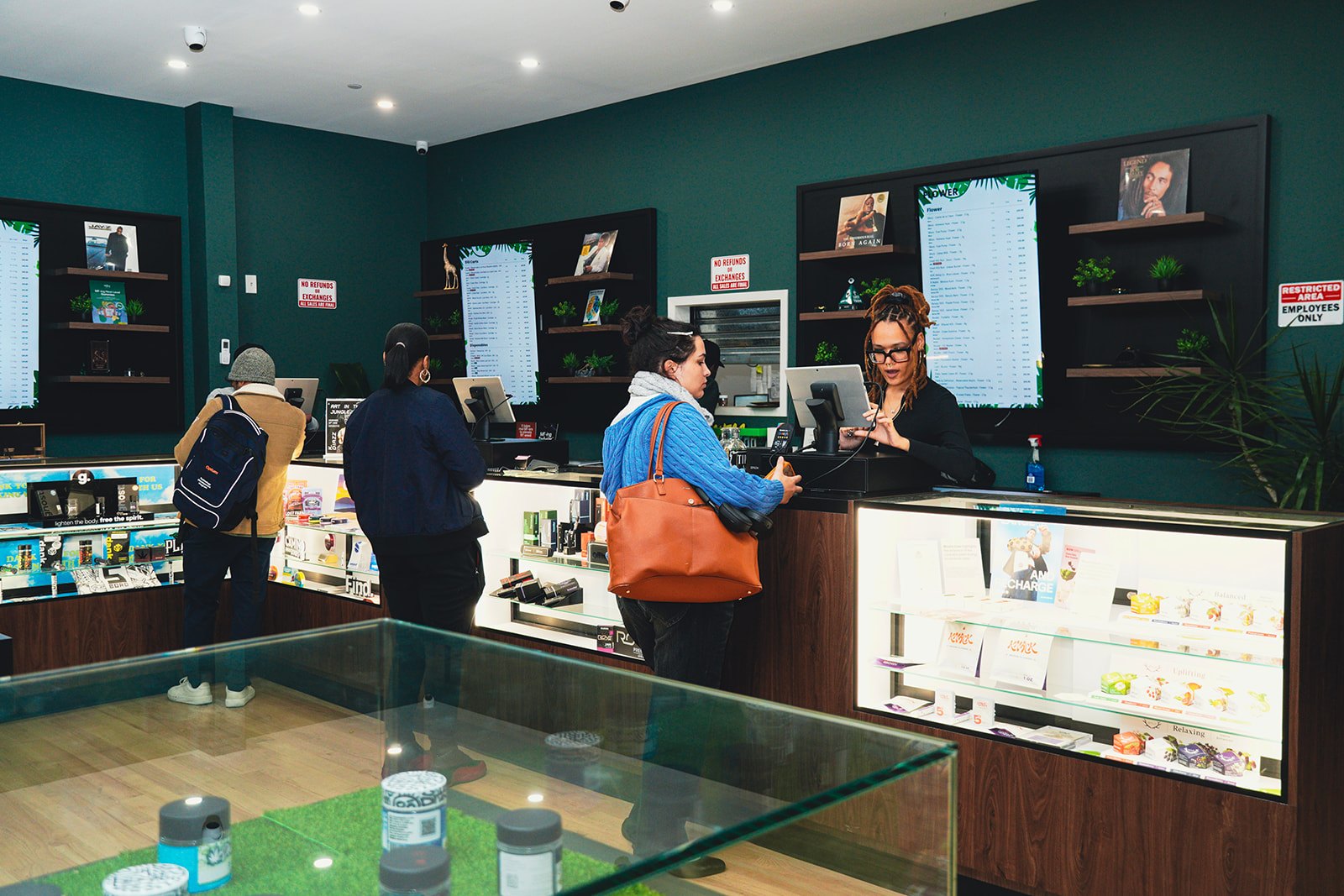Customers shopping the counter at Jungle Kingdom Flower cannabis dispensary in Bed-Stuy, Brooklyn